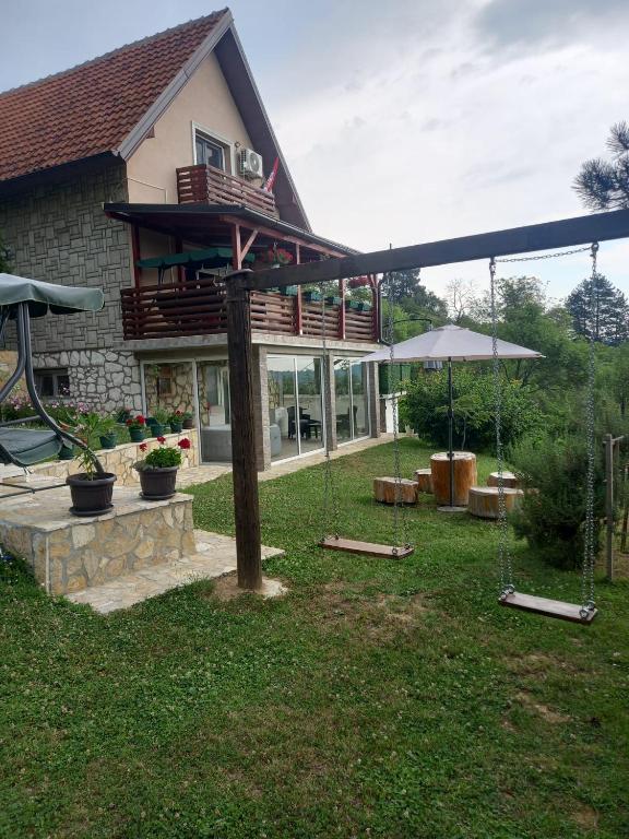 a house with a deck on the side of it at Vikendica Miličin Konak in Vrdnik