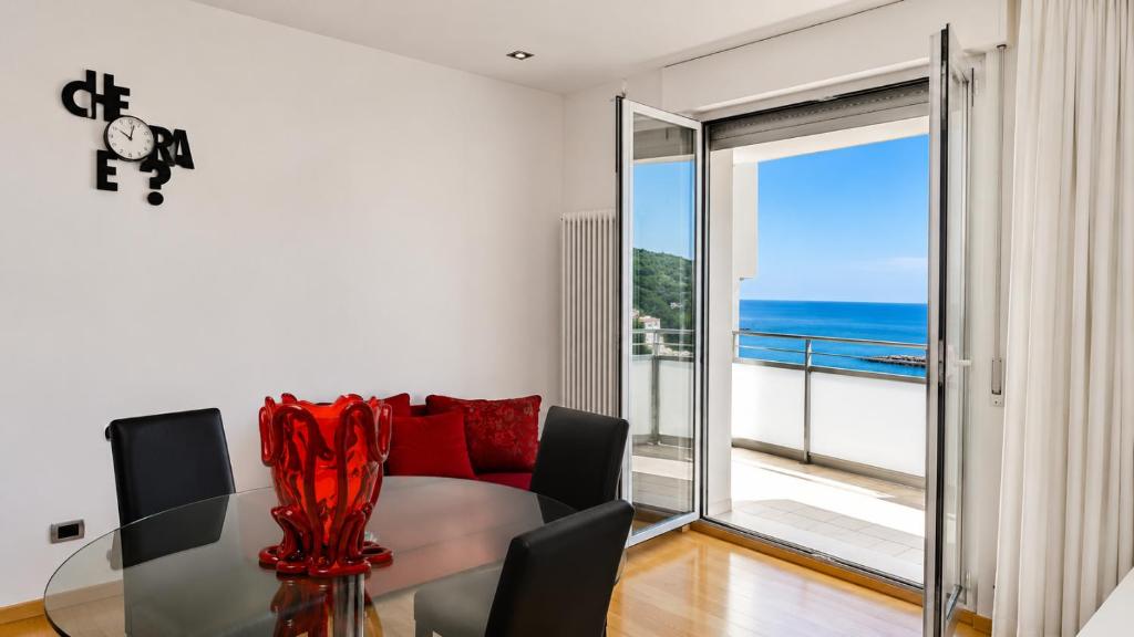 a living room with a glass table and a view of the ocean at SkyMare - Beachfront Sea View Apartment in Porto San Giorgio
