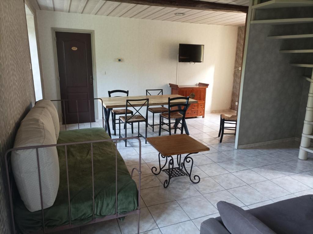 a living room with a table and chairs and a couch at L' ancien pressoir 2 in Pierrefitte-en-Cinglais