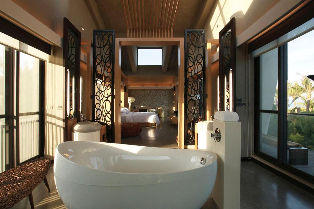 a bathroom with a tub in a room with windows at The House 15 Villa in Hengchun South Gate