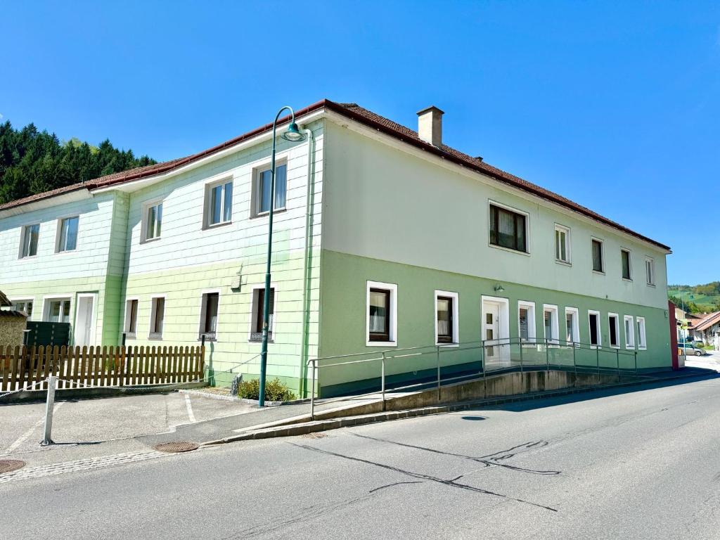 a white and green building on the side of a street at Gästehaus Kremser in Weiten