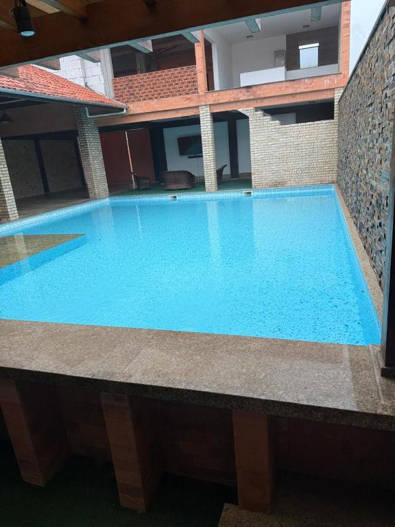 a large blue swimming pool in a building at Pousada Dona Maria in Pomerode