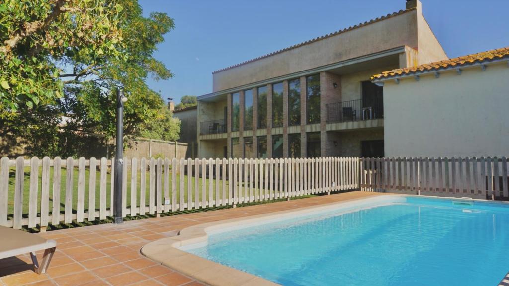 a swimming pool in front of a white fence at Can 28 in Torroella de Montgrí