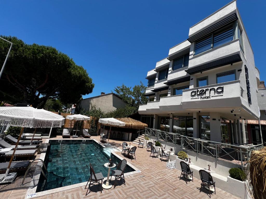 un hotel con piscina di fronte a un edificio di Aterna Hotel a Dikili