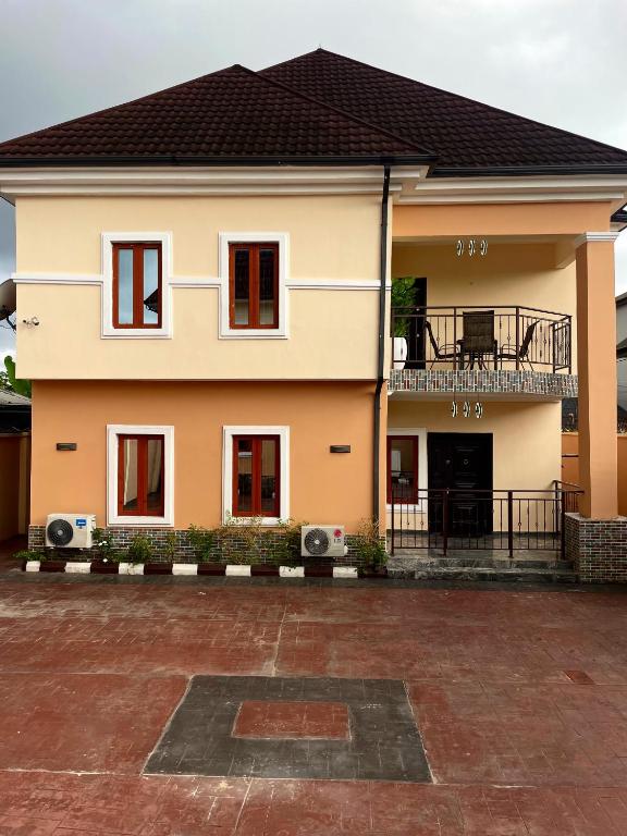 a house with a balcony and a courtyard at Davic-Mart Apartments Port Harcourt in Umudara