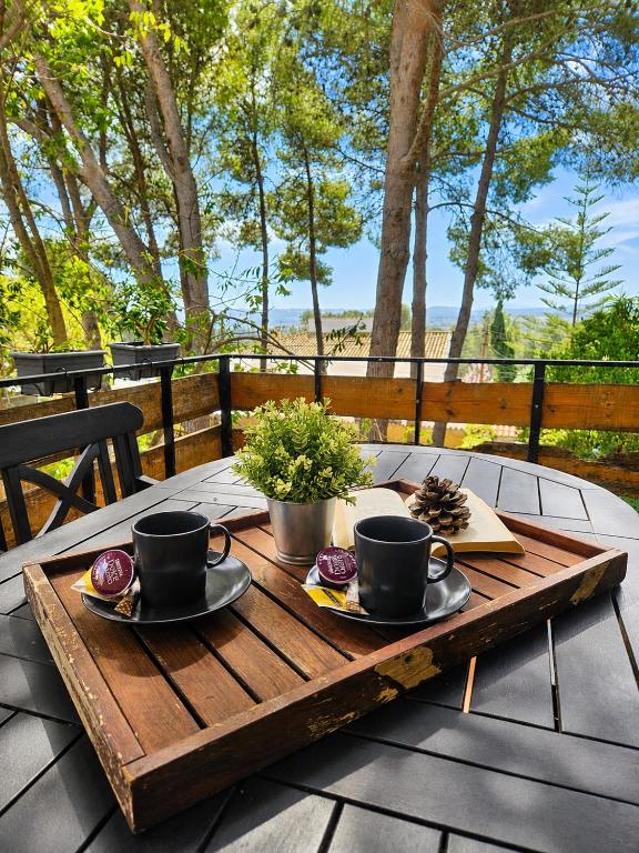 a wooden table with two cups and plates on it at Chalet con piscina y barbacoa, Valencia in Torrent