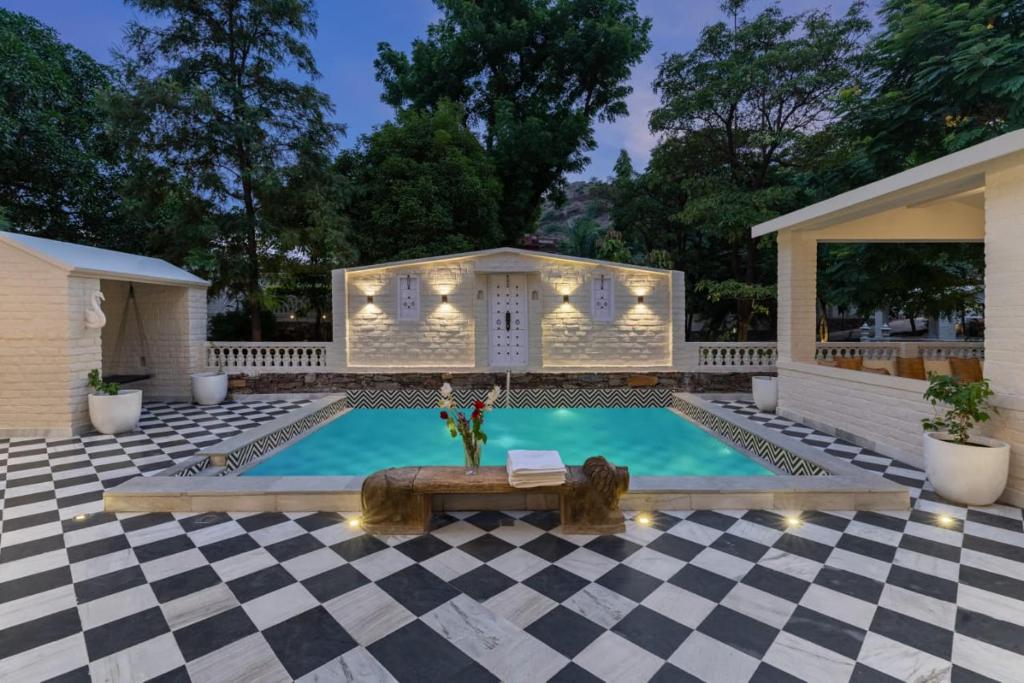 a swimming pool with a checkered floor at Emerald Hill Villa by Jodhani in Udaipur