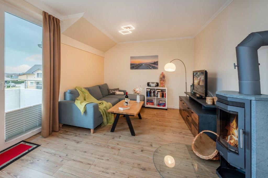 a living room with a couch and a fireplace at Ückeritz Sylva in Ueckeritz