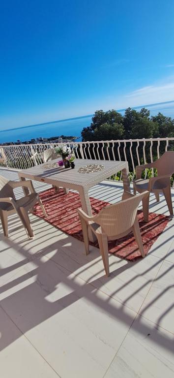 due tavoli e sedie da picnic su un patio con vista sull'oceano di Mizo Apartman a Bar