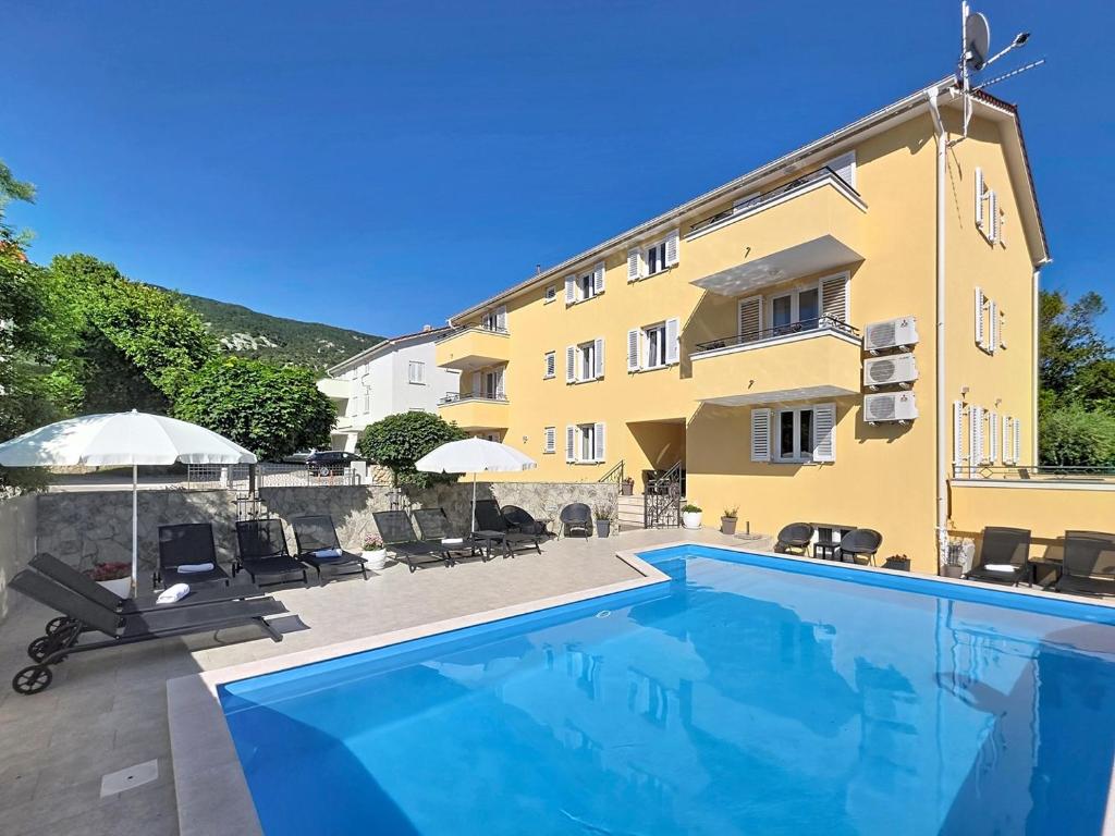 a building with a swimming pool in front of a building at House Gorica 2 - underground level apartments in Baška