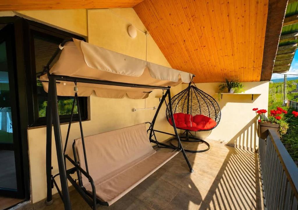 a porch with a bed and a swing at Racha Mountain Shadow in Ambrolauri