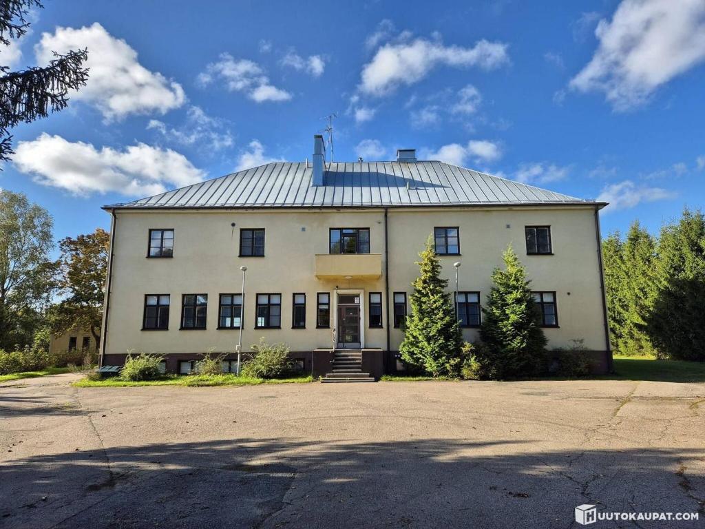 a large white building with a metal roof at Tattara School Room 2 in Nakkila