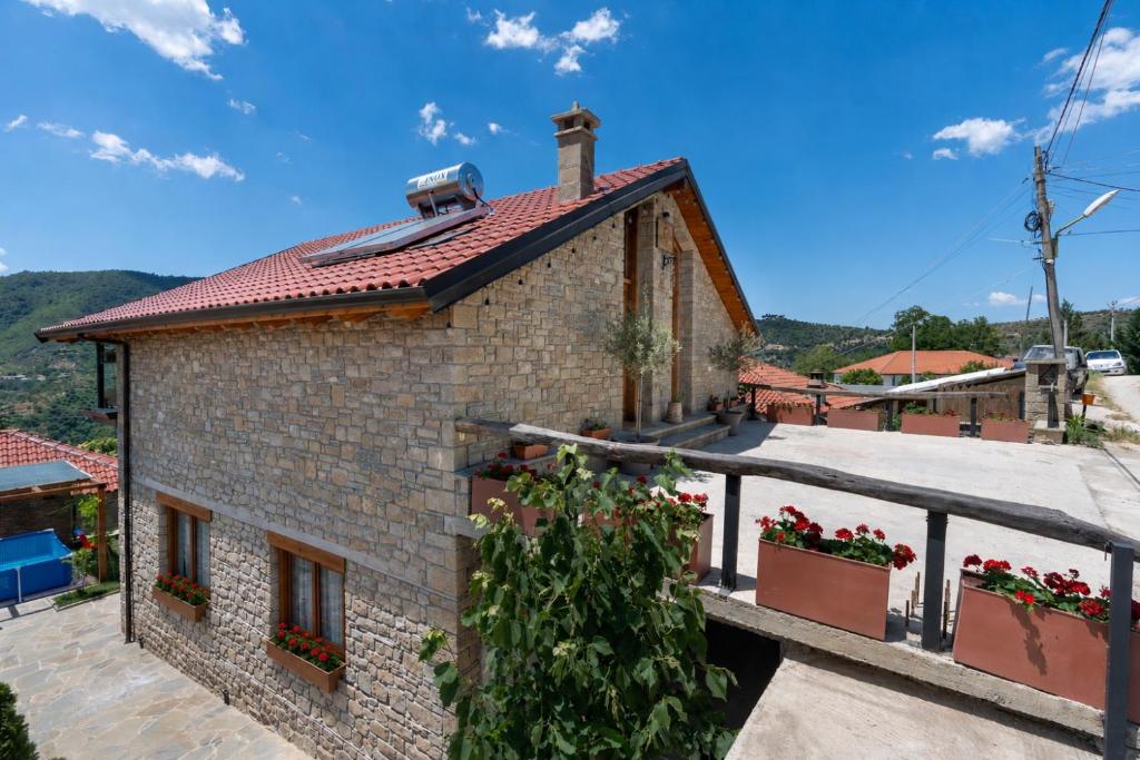 a brick house with flowers on a balcony at Vila Harmoni Roshnik in Roshnik