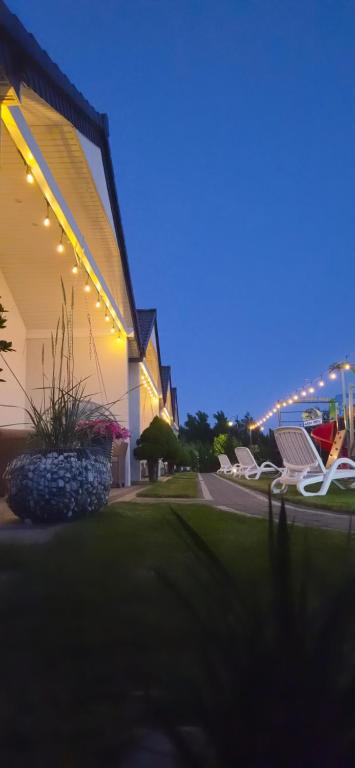 a group of chairs sitting outside of a building at night at Domki Wenta in Łeba