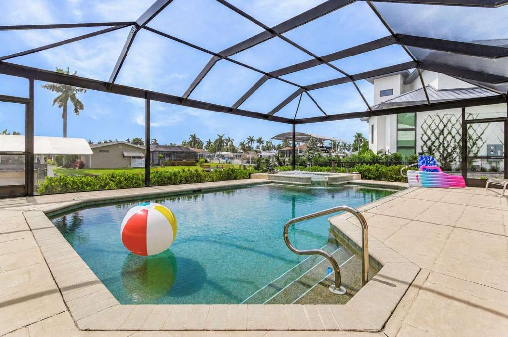 a swimming pool with a beach ball in the water at Gorgeous home with private pool & outdoor space dock in Cape Coral