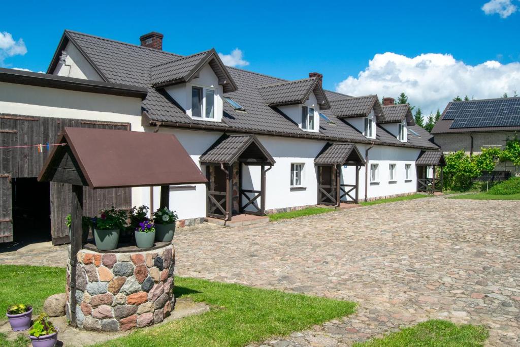 a row of white houses with a roof at Agroturystyka Nad Hańcza in Błaskowizna