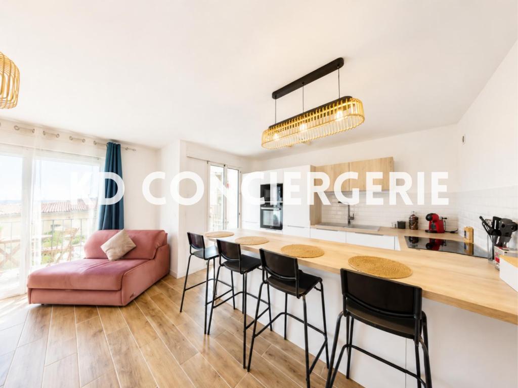 a kitchen and living room with a table and chairs at "HORIZON BLEU" - en bord de Mer in Port-de-Bouc