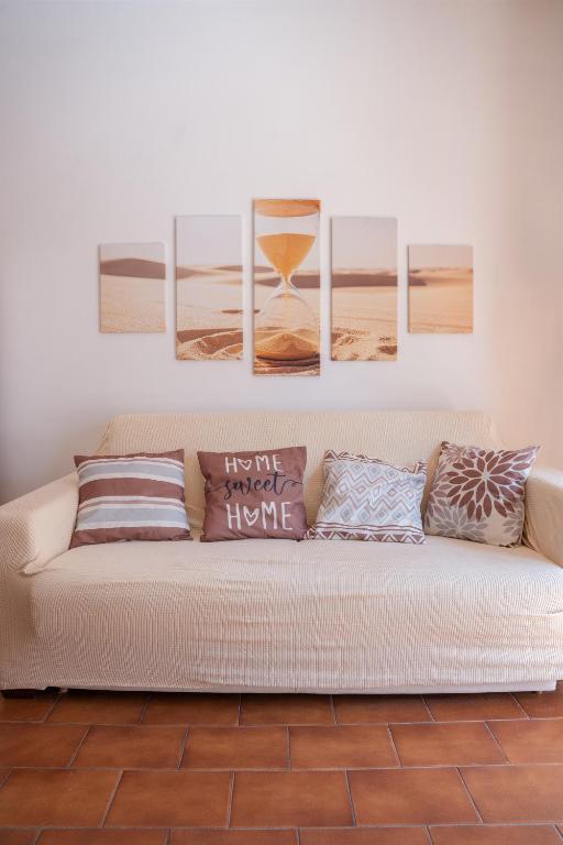 a living room with a couch with four paintings on the wall at Kronos House in Torre del Lago Puccini