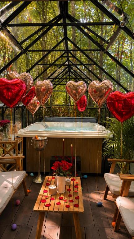 a hot tub in a greenhouse with hearts hanging from at Montebello Chalet in Porumbacu de Sus
