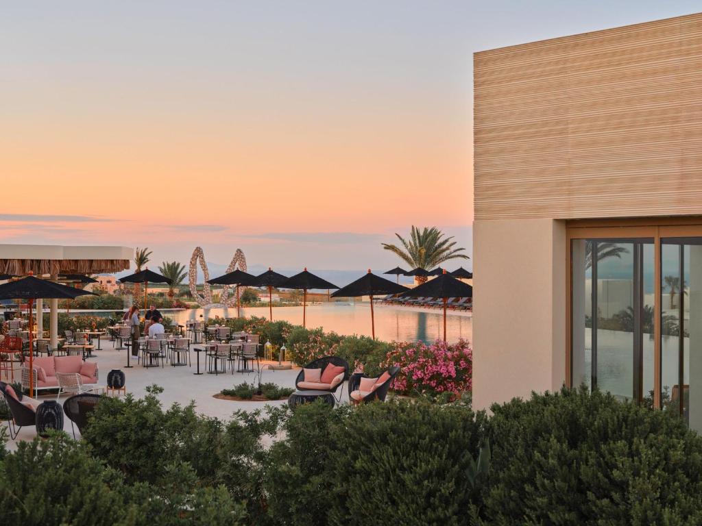a view of a resort with tables and chairs at Noūs Santorini, a Member of Design Hotels in Mesaria