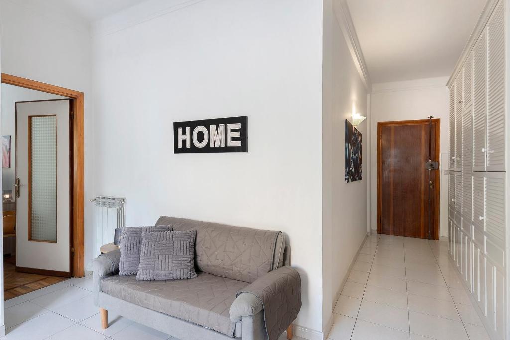a living room with a couch and a home sign on the wall at La Rosa Blu Vacation Home in Sanremo