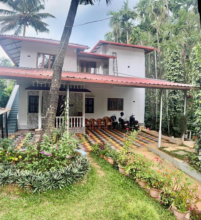 a house with a lot of plants in front of it at Ira Homestay in Sringeri