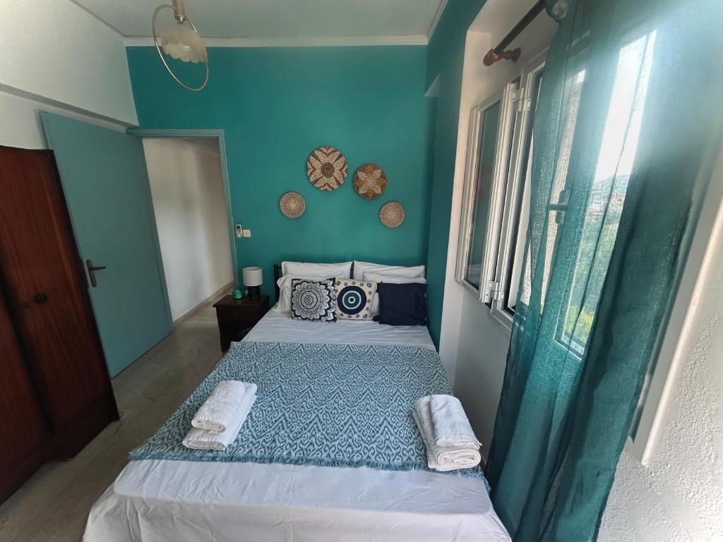 a small bedroom with a bed with blue walls at Stay for 2 by Alecos Studios in Poros