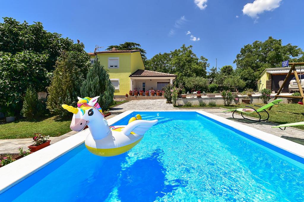 a unicorn float in a pool in a yard at House Roza 2065 in Žminj