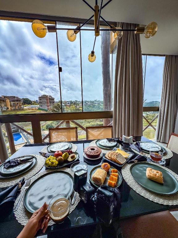 a table with plates of food on top of a balcony at Sossego na serra vista para vale e lazer completo in Bananeiras