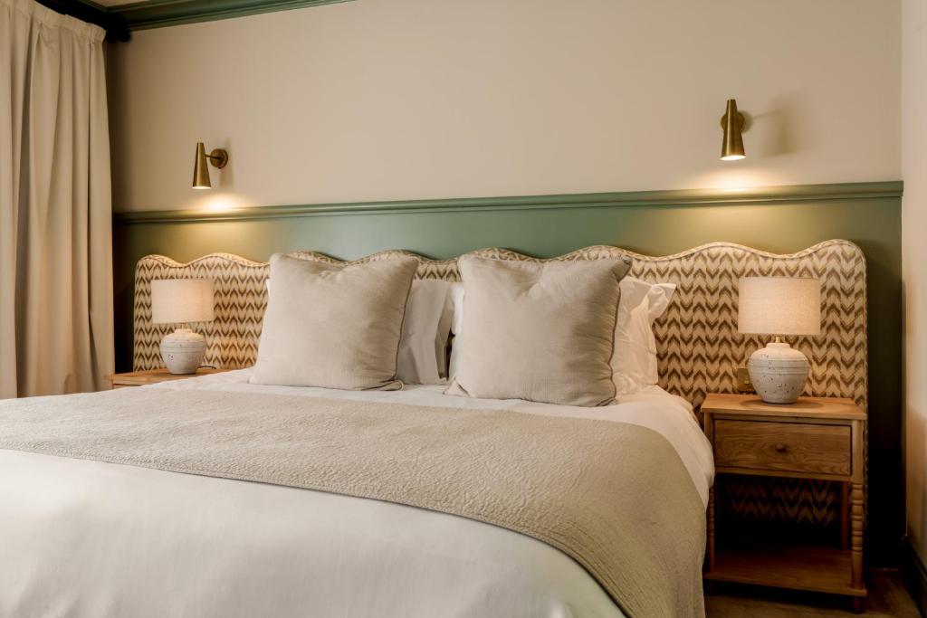 a bedroom with a large bed with white sheets and pillows at Dartmoor Lodge in Ashburton