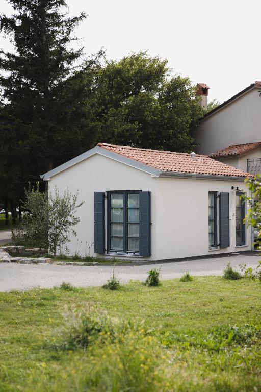 a white house with black windows on a street at Villa Eva in Ajdovščina