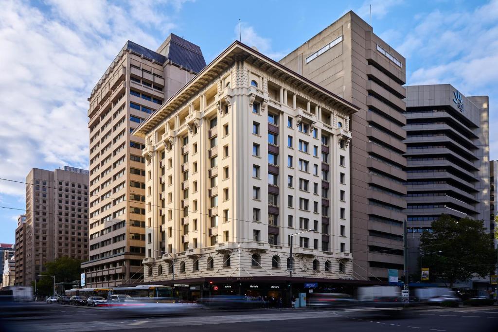 a tall building on a city street with buildings at Mantra Adelaide Central in Adelaide