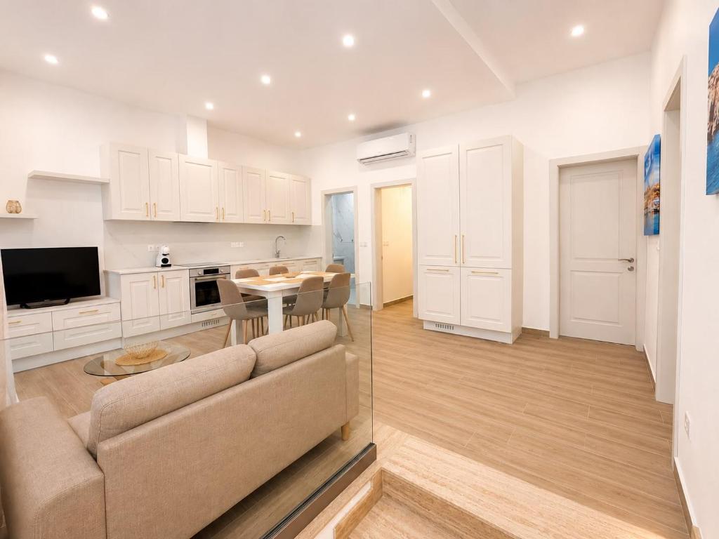 a living room with a couch and a table at Il-Kenn ta Roża Maisonette in Qala