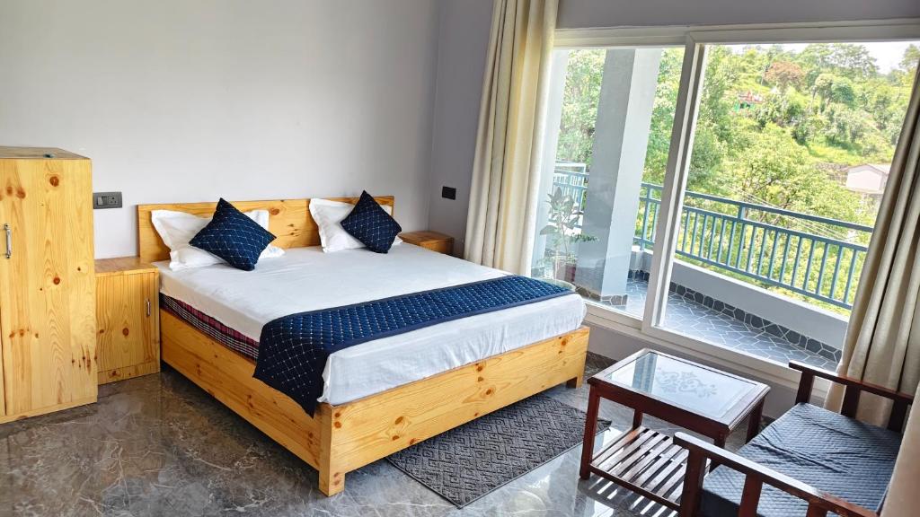 a bedroom with a bed and a large window at Ganga Nature Nest in Hawālbāgh
