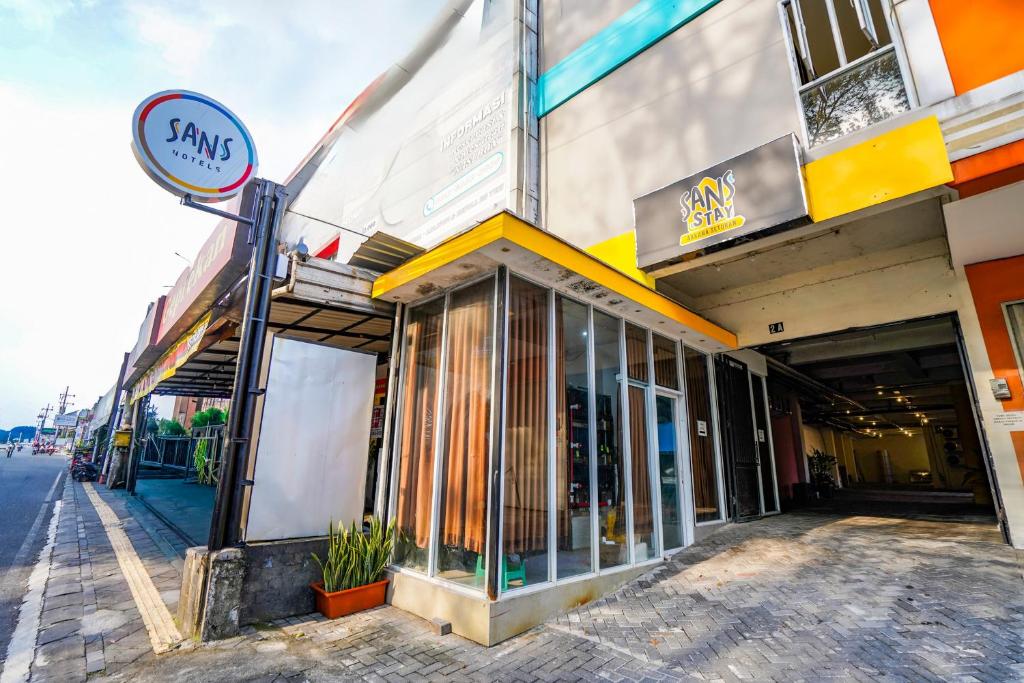 a building with a sign on the side of a street at SANS Stay Arkana Seturan Pakuwon Mall in Yogyakarta