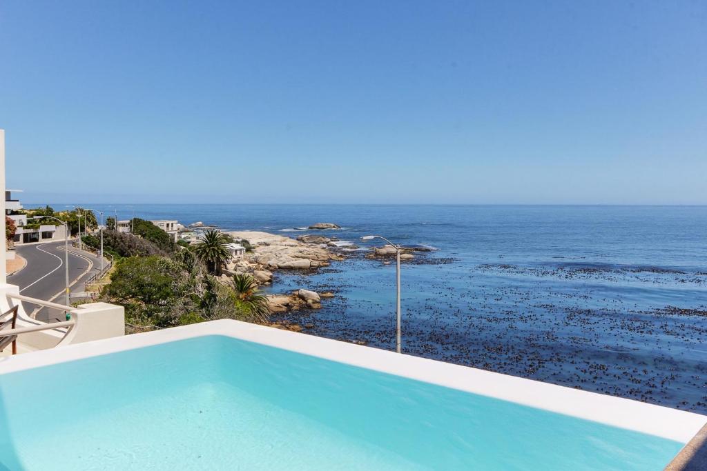 a swimming pool with a view of the ocean at Bali Luxury Suite C in Cape Town