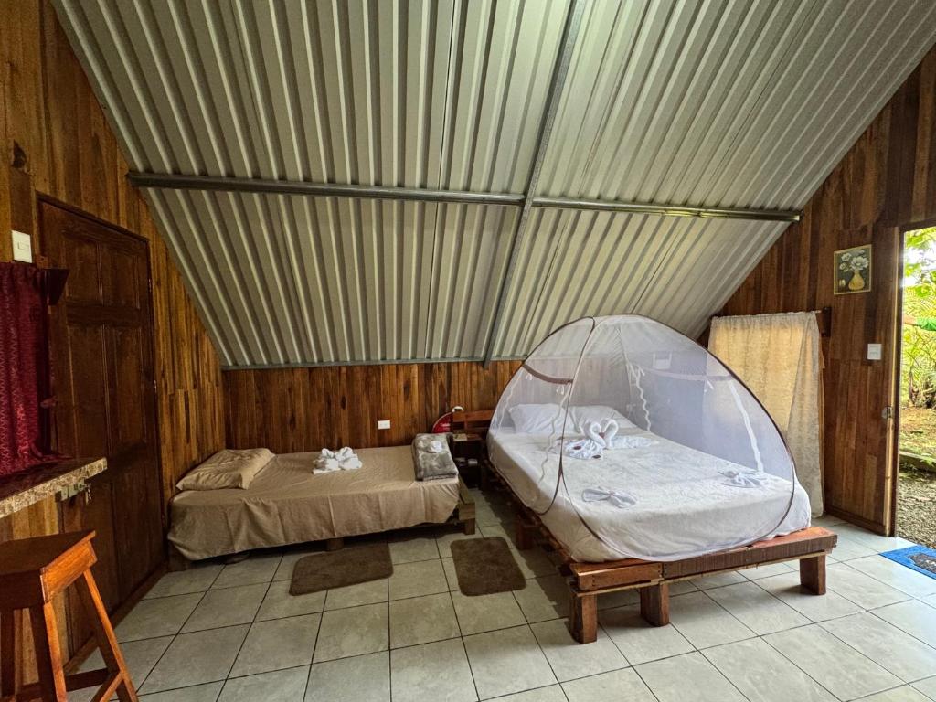 a room with two beds and a tent at Cabaña Escondida Rio Celeste in El pilon