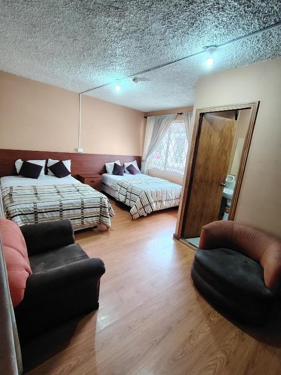 a living room with two beds and a couch at Hostal el barranco in Cuenca