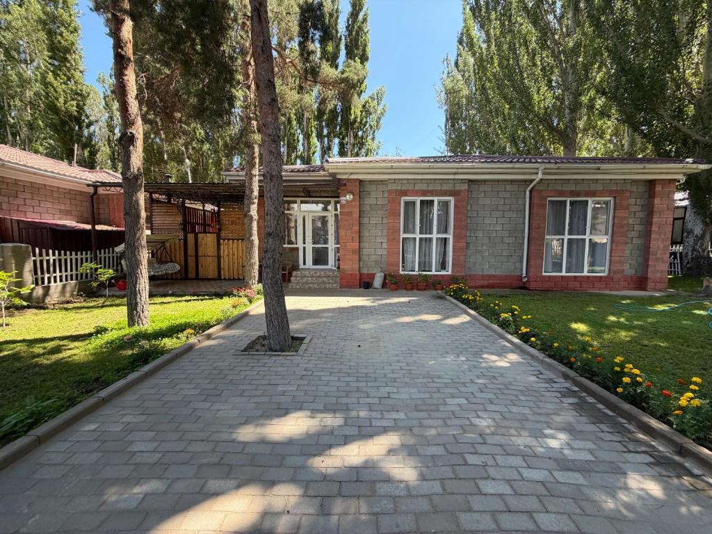 a brick house with a tree in the driveway at РадугаВест58а in Koshkolʼ