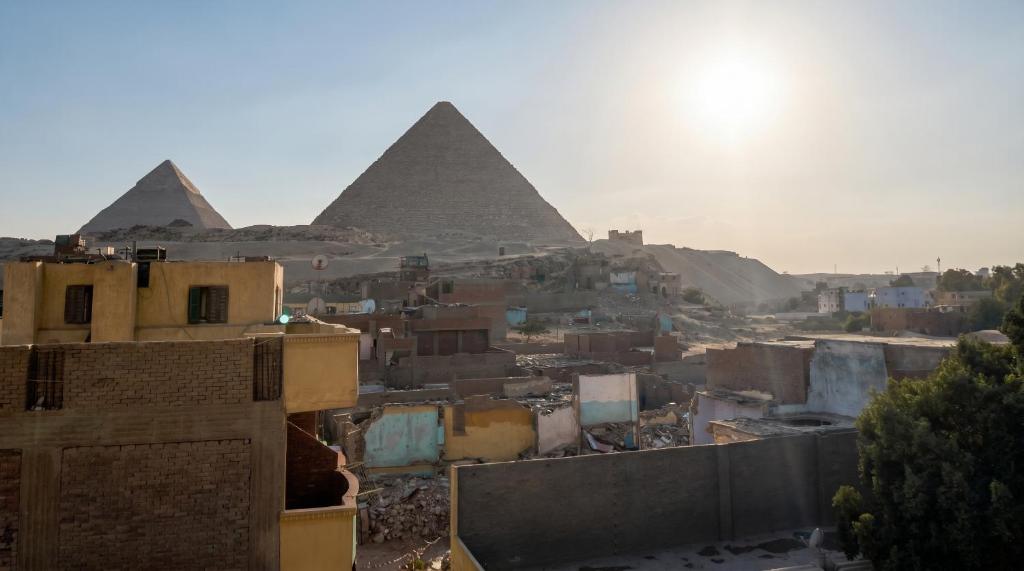 a view of the pyramids of giza and a city at Sunset Mirage House in Giza