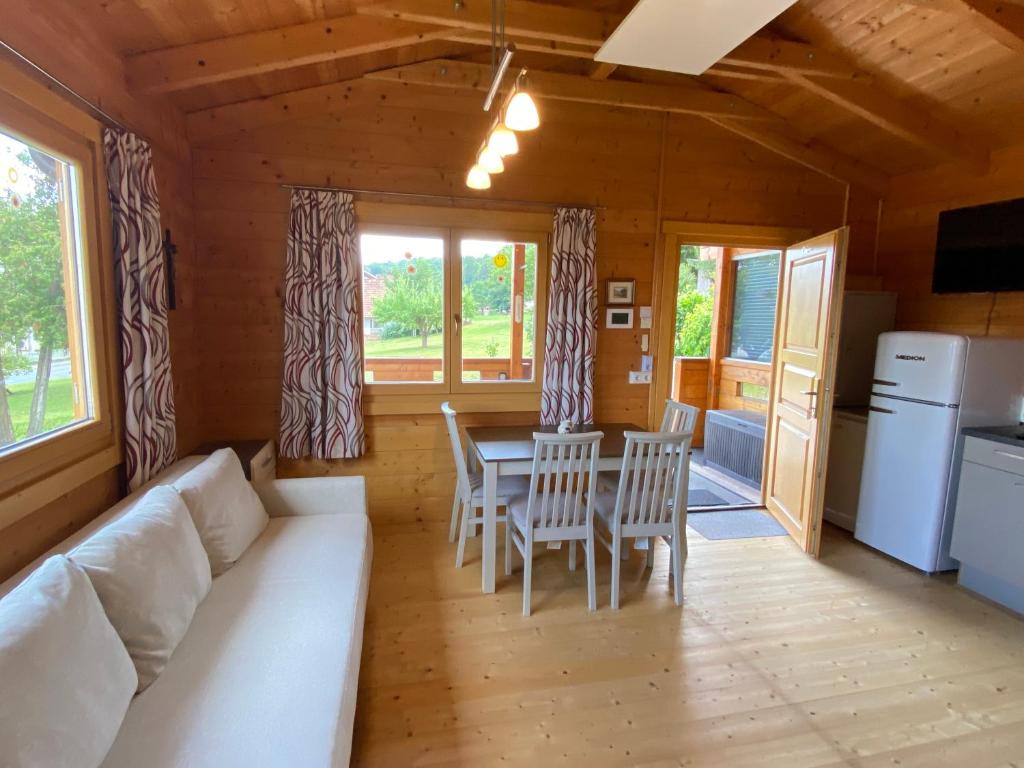 a living room with a white couch and a table and chairs at Blockhaus Nikolaus in Güssing