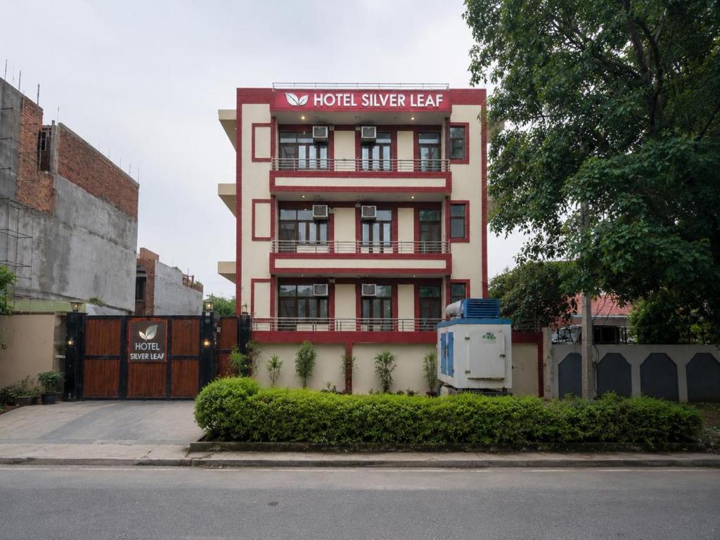 a red building with a sign on top of it at Hotel Silver Leaf, Noida in Noida