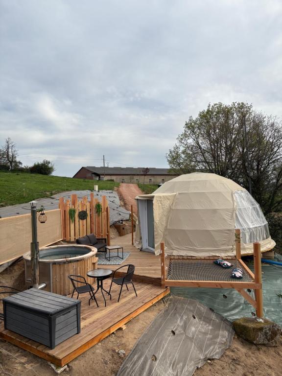 a gazebo with a table and chairs on a wooden deck at Le dôme de Clem in Figeac