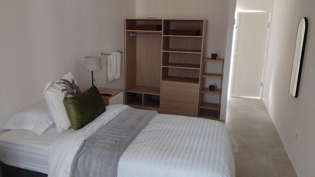 a bedroom with a white bed and a closet at Muzhi Wetu Lodge in Chanamo