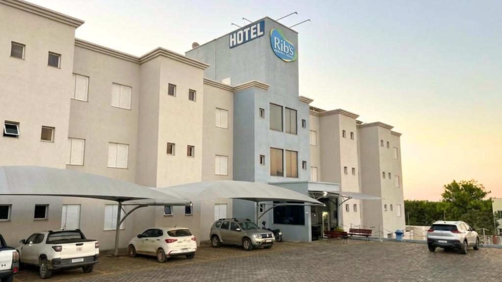 a hotel with cars parked in front of it at Ribs Hotel in Piauí