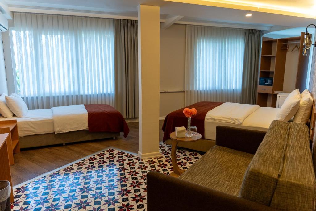 a hotel room with two beds and a couch at The MU City Hotel Trabzon in Trabzon