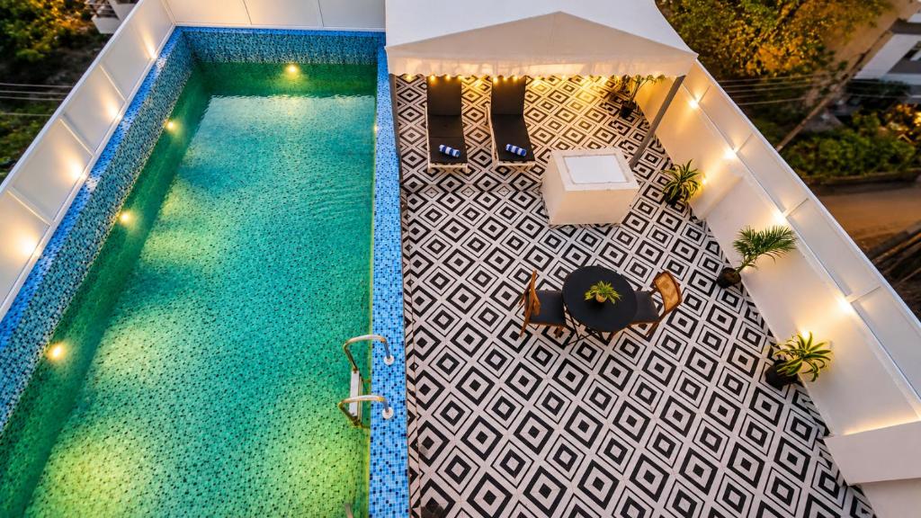 an overhead view of a swimming pool with a table and chairs at HOTEL GREEN VEGAS in New Delhi
