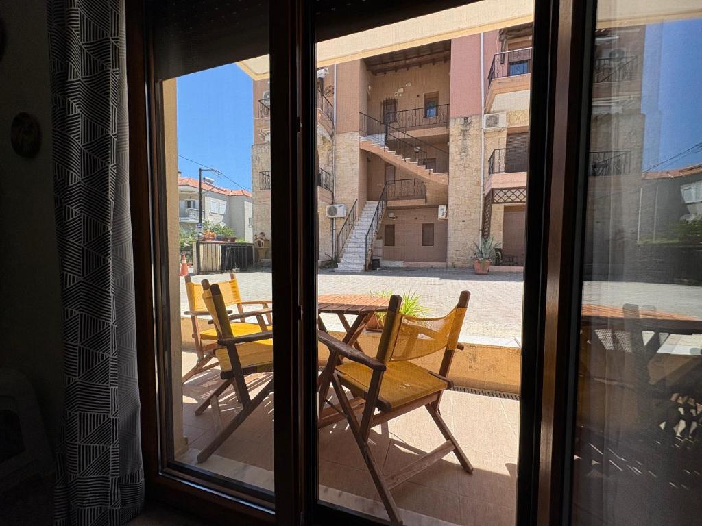 a view of a table and chairs from a window at Afytos Family Apartment in Afitos