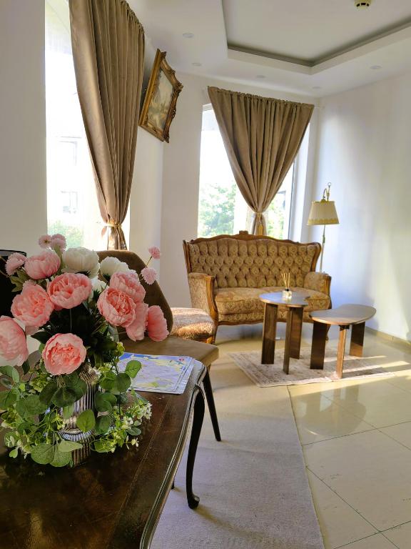 a living room with a couch and a table with flowers at Family Hotel Brilliance in Varna City