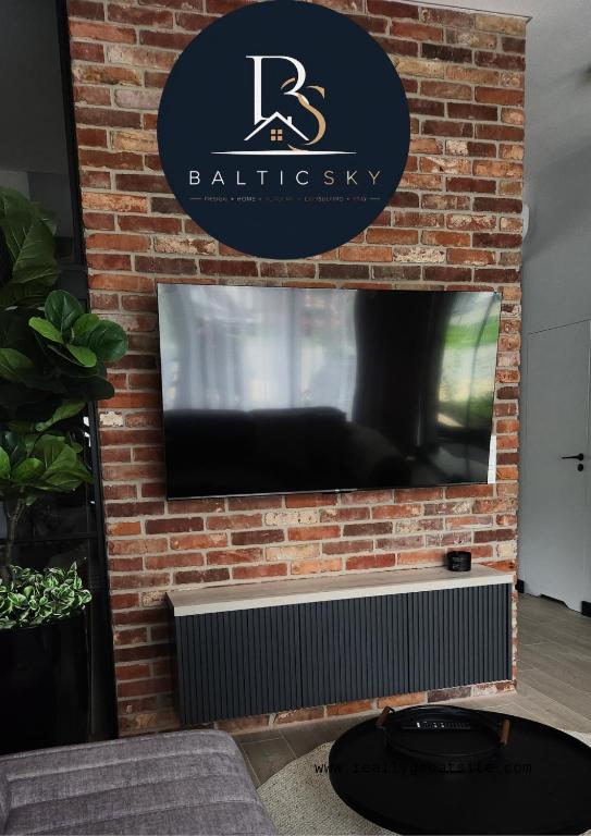 a brick wall with a flat screen tv on it at BalticSky Loft Premium, Apartament Kołobrzeg, Basen, Jacuzzi, Sauna in Kołobrzeg